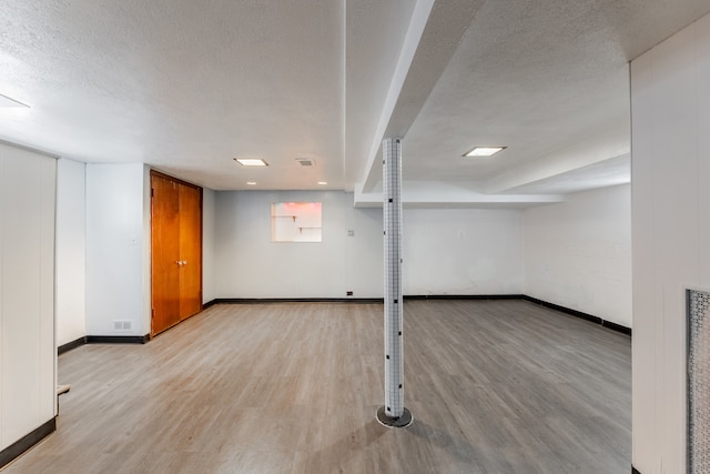 basement with a textured ceiling and hardwood / wood-style flooring