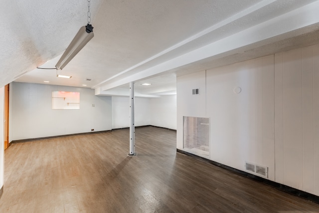 basement with hardwood / wood-style floors and a textured ceiling