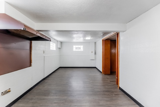 basement featuring a textured ceiling and dark hardwood / wood-style flooring