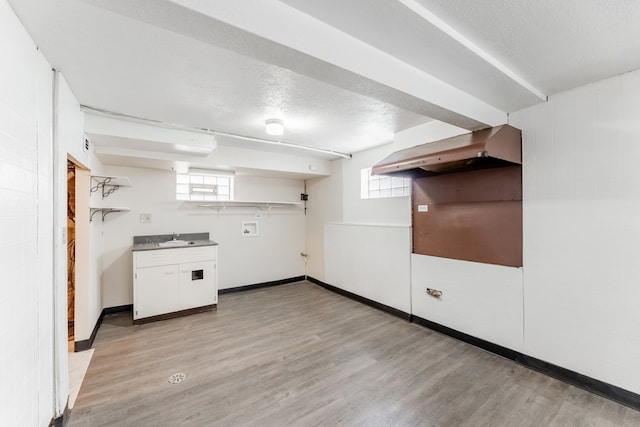 interior space featuring sink, a healthy amount of sunlight, a textured ceiling, and light hardwood / wood-style floors