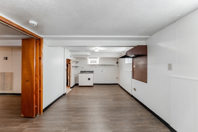 kitchen with white cabinets, a textured ceiling, hardwood / wood-style flooring, and extractor fan