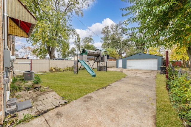 view of yard with a playground, a garage, an outdoor structure, and central air condition unit