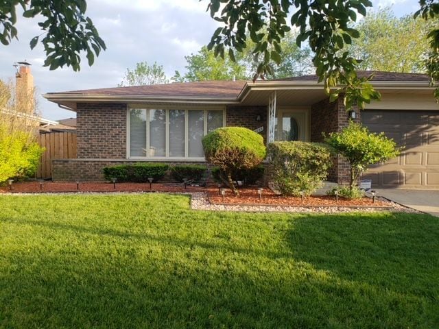 single story home with a garage and a front lawn