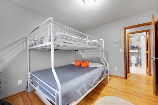 bedroom with hardwood / wood-style floors and ensuite bathroom