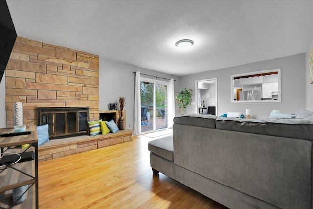 living room featuring a stone fireplace and hardwood / wood-style flooring