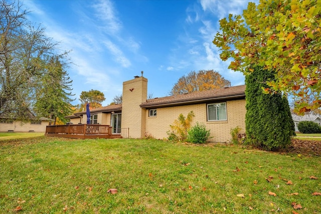 back of property with a lawn and a deck