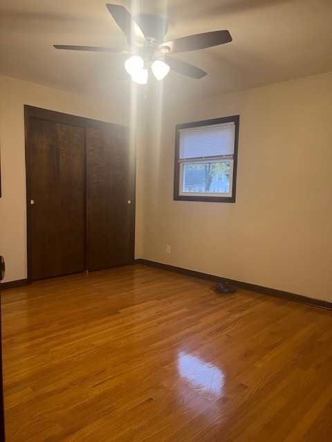 unfurnished bedroom featuring light wood-type flooring, ceiling fan, and a closet