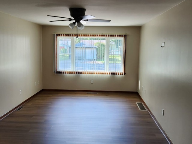 spare room featuring dark wood-type flooring and ceiling fan