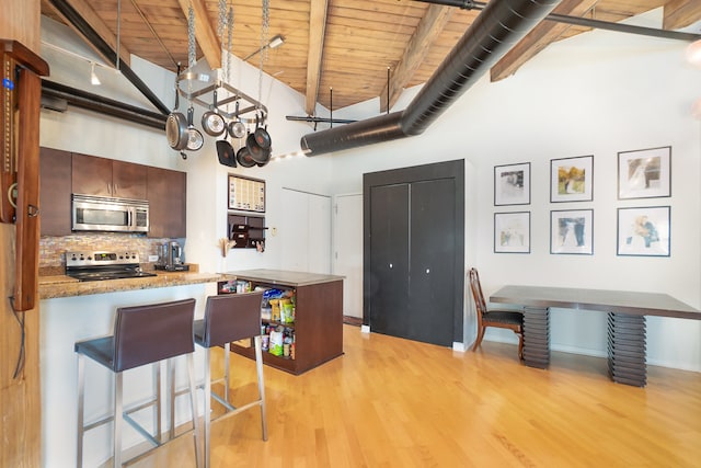 kitchen featuring high vaulted ceiling, light hardwood / wood-style flooring, wooden ceiling, and stainless steel appliances