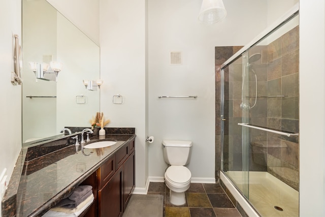 bathroom featuring vanity, toilet, and a shower with shower door