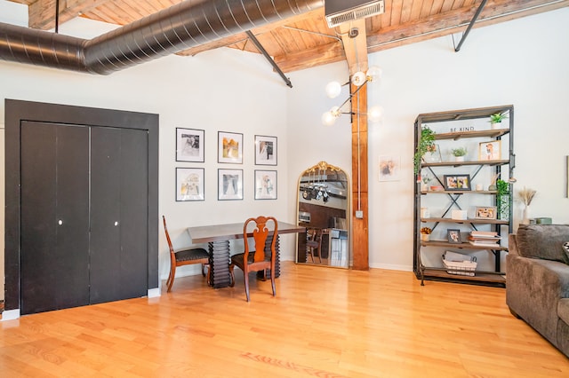 dining area featuring hardwood / wood-style flooring, beam ceiling, and wood ceiling