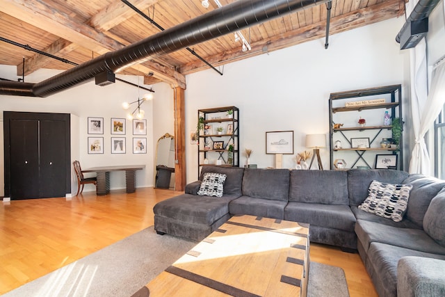 living room with a high ceiling, wood-type flooring, wood ceiling, and beam ceiling