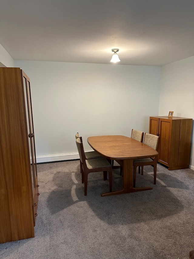 carpeted dining room featuring a baseboard heating unit