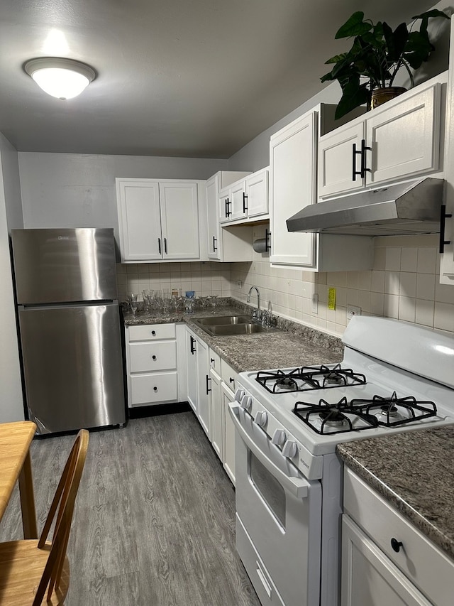 kitchen featuring sink, white gas range oven, stainless steel fridge, dark hardwood / wood-style flooring, and white cabinetry