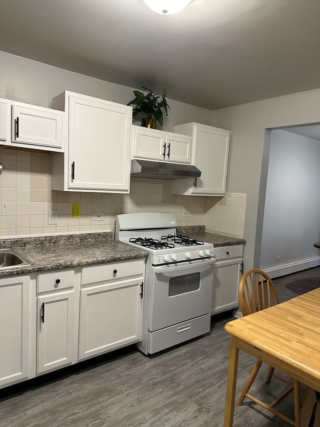 kitchen featuring a baseboard heating unit, white cabinets, decorative backsplash, white gas range, and dark hardwood / wood-style flooring