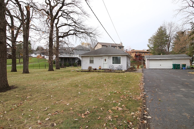 view of front of house featuring an outbuilding, a front yard, and a garage