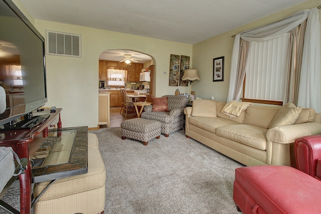 carpeted living room featuring ceiling fan