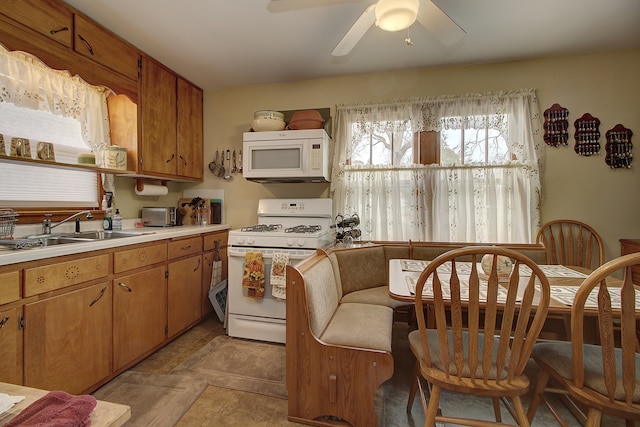 kitchen featuring ceiling fan, white appliances, and sink