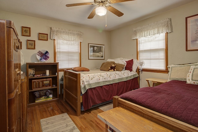 bedroom with hardwood / wood-style flooring, ceiling fan, and multiple windows