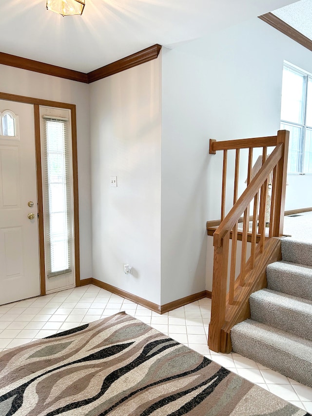 tiled foyer entrance featuring a wealth of natural light and ornamental molding