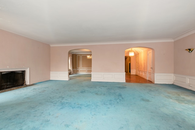 unfurnished living room featuring ornamental molding and carpet floors