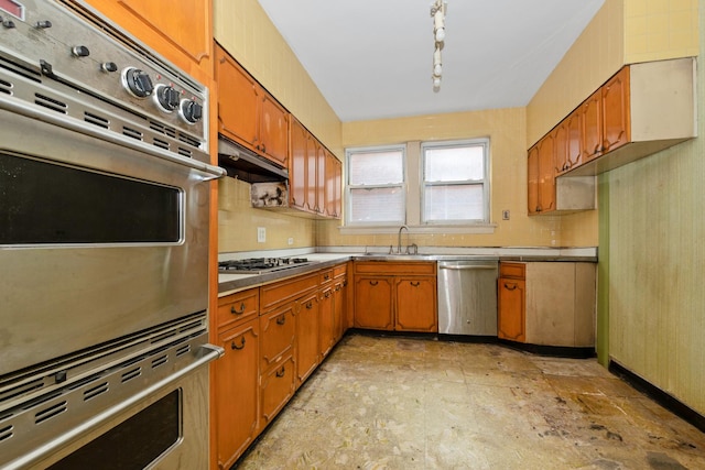 6922 S Jeffery Blvd Unit 3S, Chicago, IL 60649 - kitchen featuring appliances with stainless steel finishes, a sink, brown cabinetry, under cabinet range hood, and light countertops