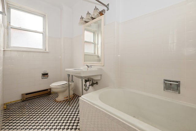 bathroom with tile patterned floors, toilet, tiled tub, and a baseboard radiator