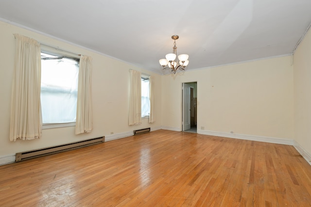 spare room with a chandelier, light wood-type flooring, plenty of natural light, and ornamental molding