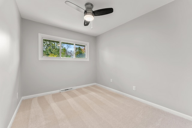 carpeted spare room with ceiling fan