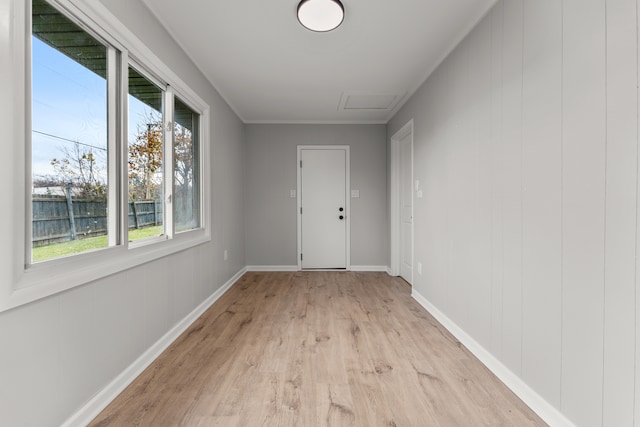 doorway with light wood-type flooring and crown molding