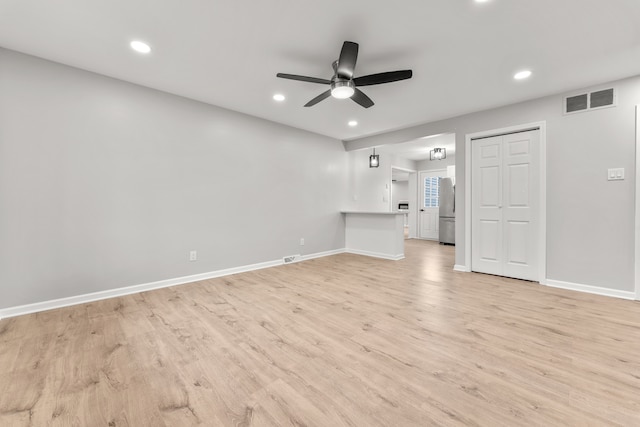 unfurnished living room featuring ceiling fan and light wood-type flooring