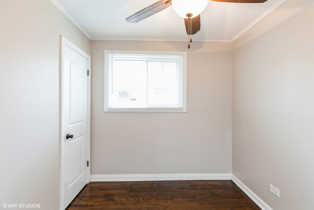 empty room with ornamental molding, dark wood-type flooring, and ceiling fan