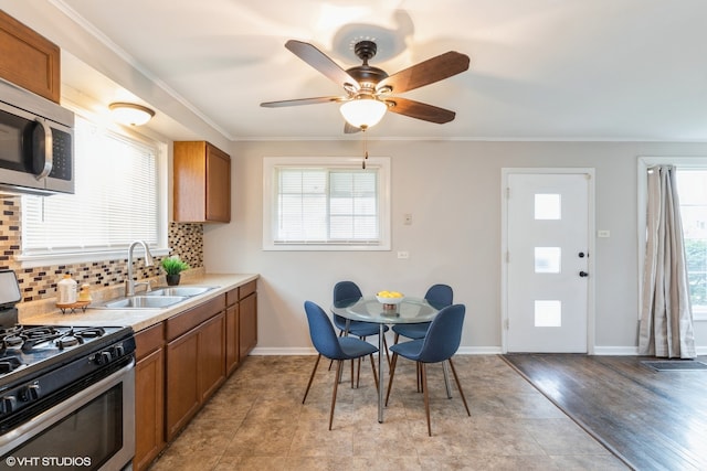 kitchen featuring sink, appliances with stainless steel finishes, tasteful backsplash, ceiling fan, and light wood-type flooring