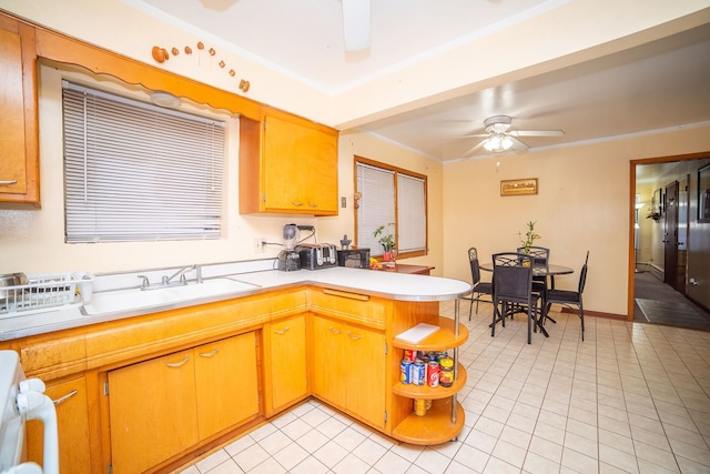 kitchen featuring ceiling fan, kitchen peninsula, and light tile patterned flooring