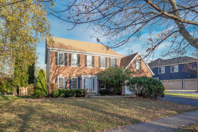 colonial-style house featuring a front yard