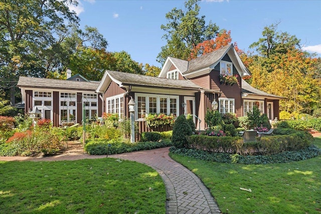 rear view of house with a sunroom and a lawn