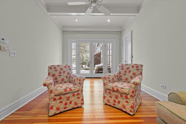 sitting room featuring beamed ceiling, french doors, ornamental molding, ceiling fan, and light hardwood / wood-style flooring