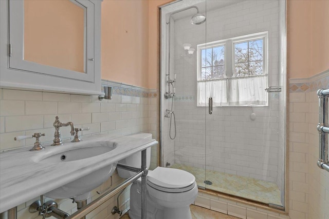 bathroom featuring toilet, walk in shower, and tile walls