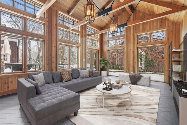 sunroom featuring wood ceiling, lofted ceiling with beams, and a chandelier