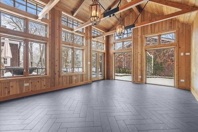 unfurnished sunroom with plenty of natural light, wooden ceiling, vaulted ceiling with beams, and a chandelier