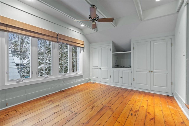 unfurnished living room featuring light hardwood / wood-style floors, ceiling fan, and vaulted ceiling with beams