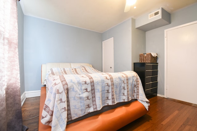 bedroom featuring dark hardwood / wood-style floors, ceiling fan, and ornamental molding