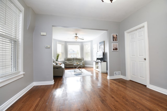 unfurnished living room featuring ceiling fan and dark hardwood / wood-style flooring