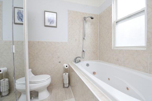 bathroom with shower with separate bathtub, tile walls, and toilet