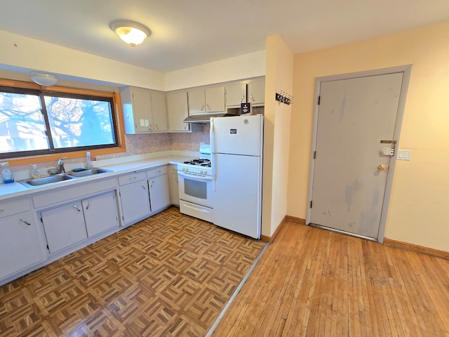 kitchen with white appliances, gray cabinetry, sink, and light hardwood / wood-style floors