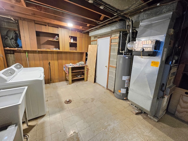 basement with water heater, heating unit, wooden walls, and washer and dryer