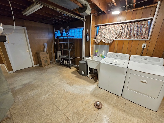 laundry area with wood walls and washing machine and clothes dryer