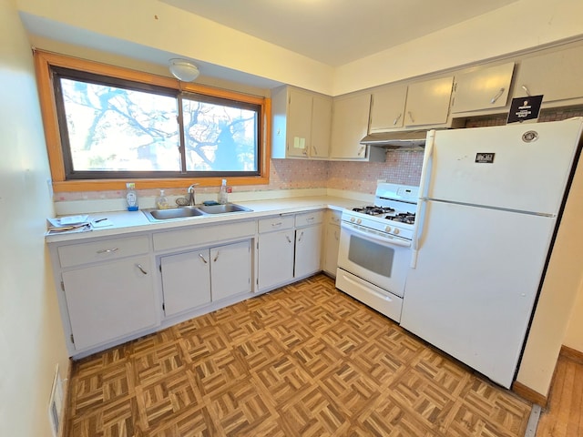 kitchen with light parquet flooring, sink, white appliances, and backsplash