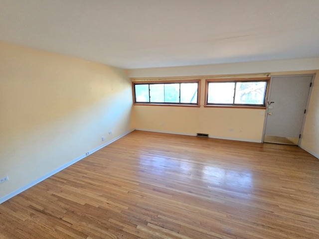 spare room with a wealth of natural light and light hardwood / wood-style flooring