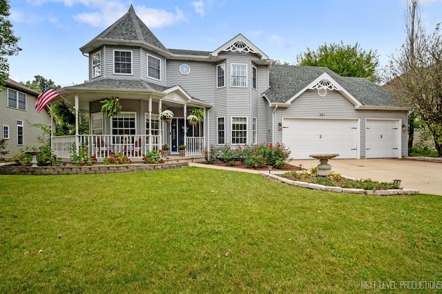 victorian-style house featuring a garage, a front yard, and a porch